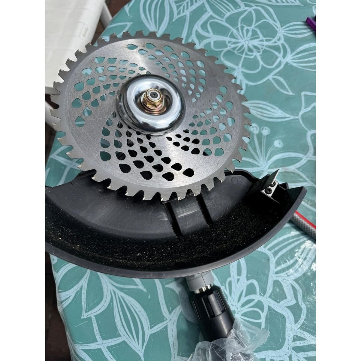 Clearing patio weeds with brush attachment